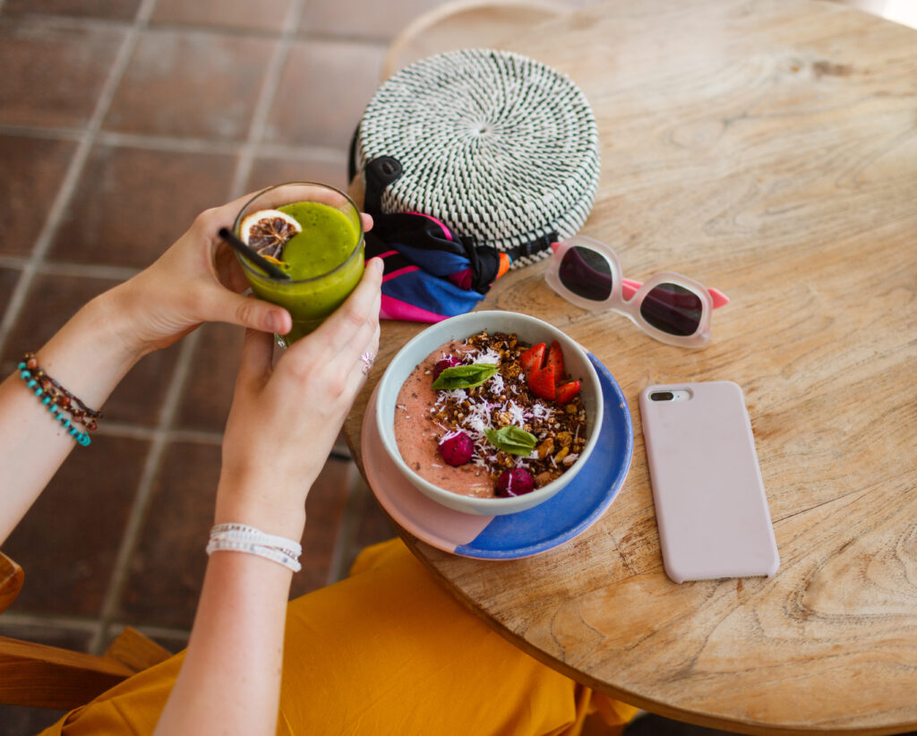 woman-holding-smoothie-superfoods-bowl-topped-with-chia-granola-avocado